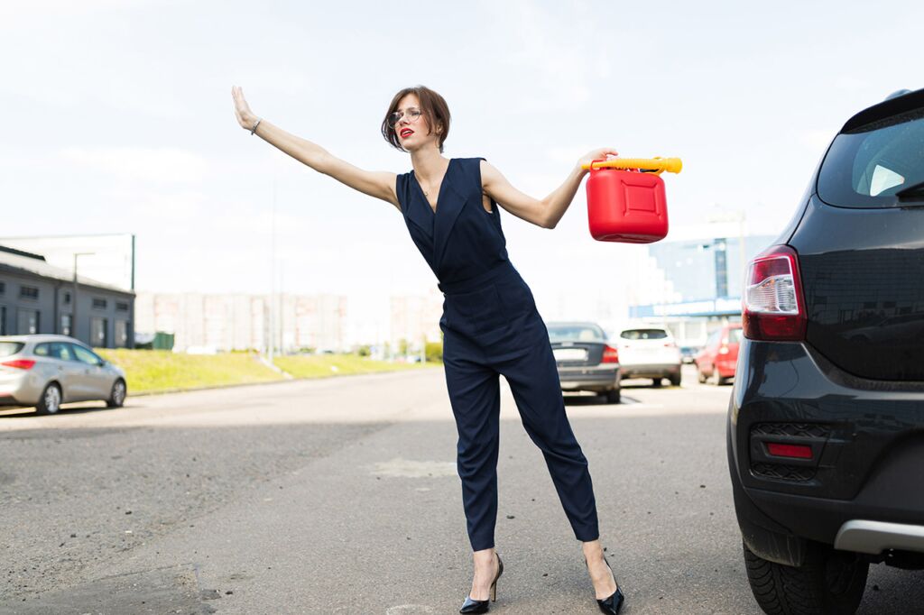 Woman in Blue Waiting on Fuel Delivery Service with Red Plastic Fuel Canister